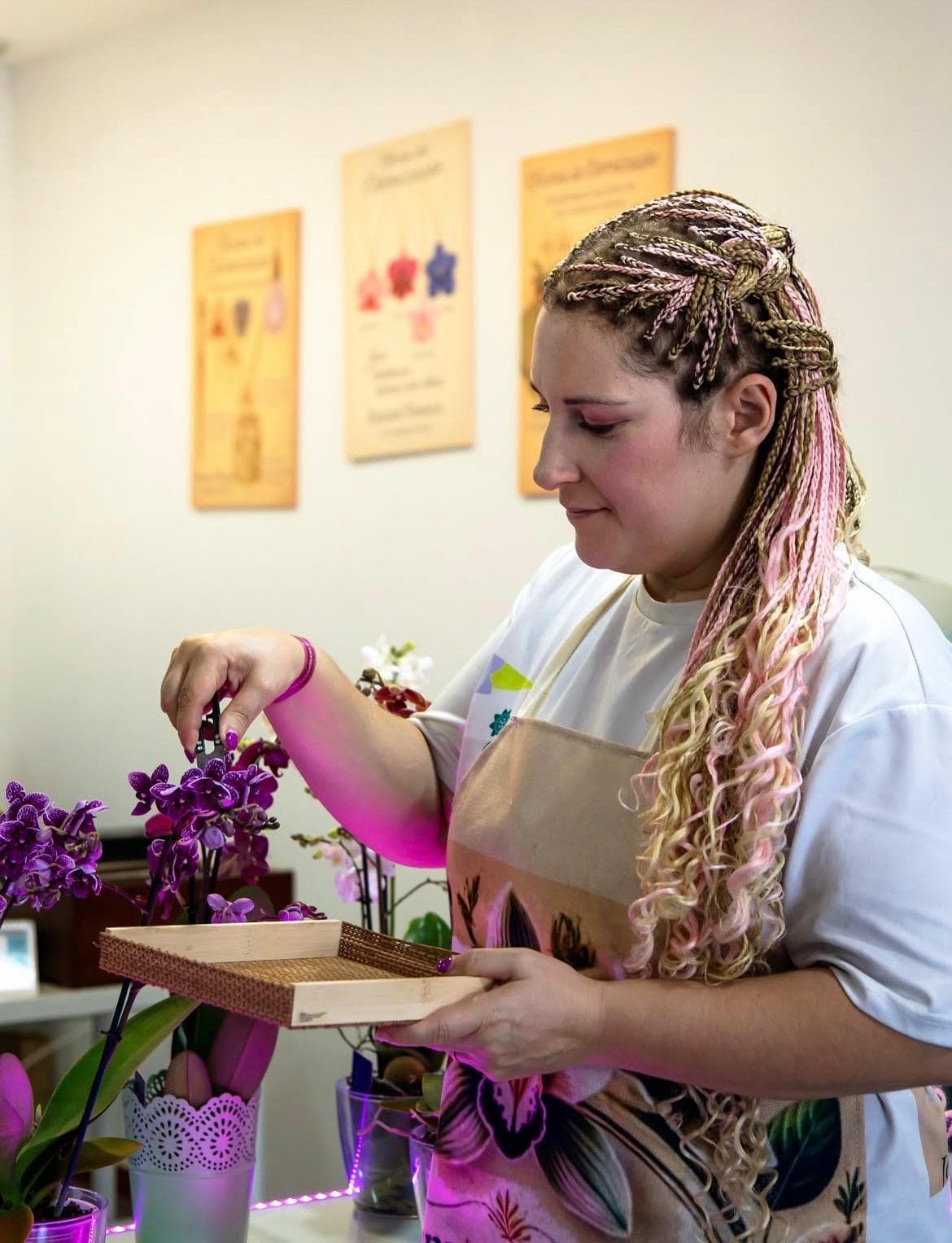 Marina a trabalhar com orquídeas, uma tesoura e um tabuleiro de madeira
