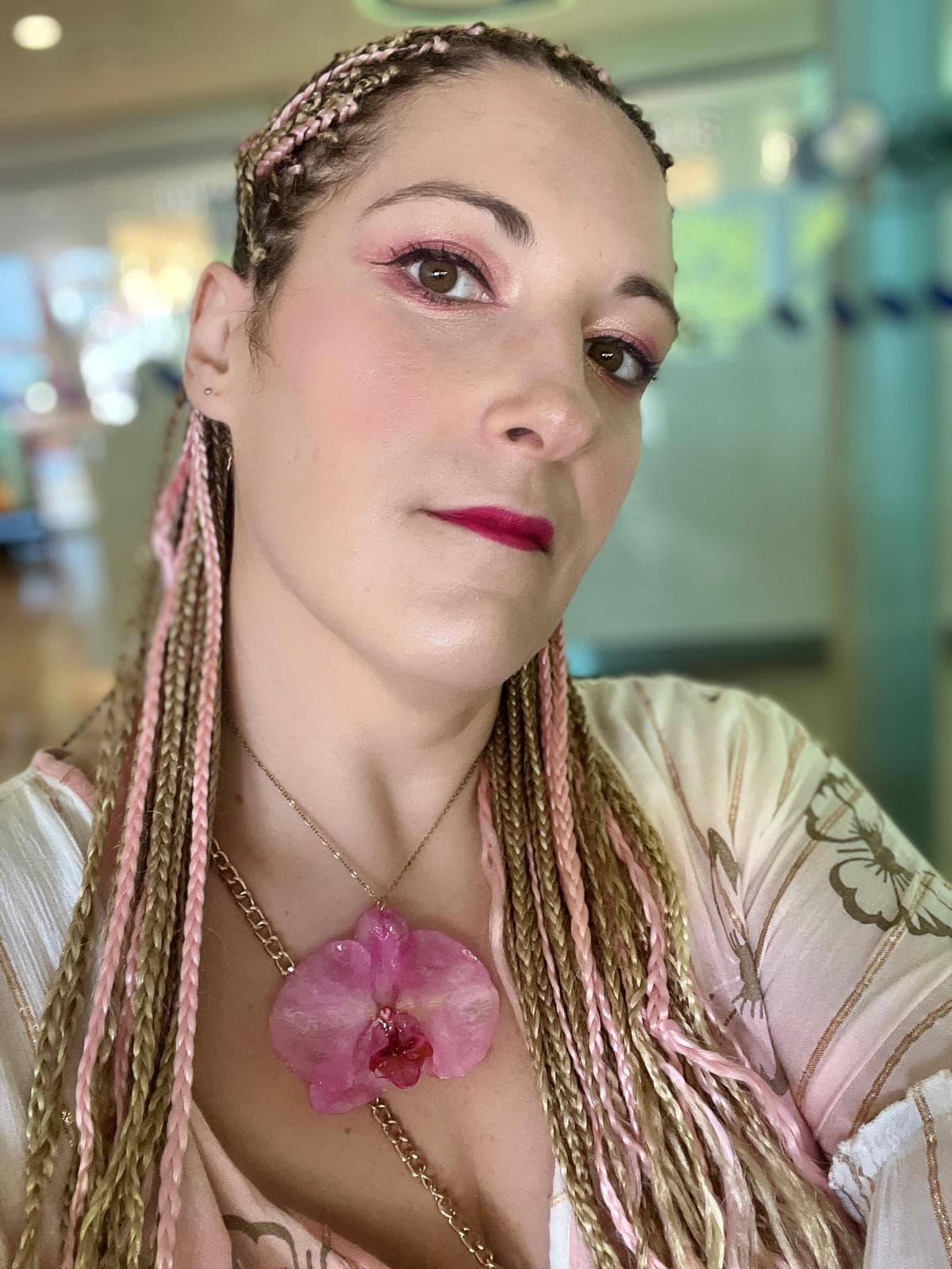 Marina, fundadora da Eternal Flowers, com uma orquídea rosa ao peito